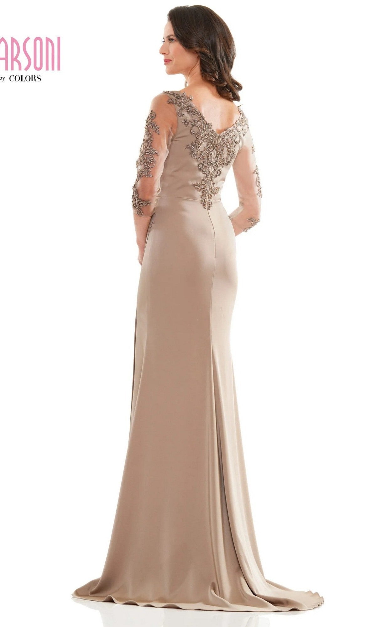 A woman faces away from the camera wearing the Marsoni MV1146, a long beige formal dress featuring embroidered sleeves and lace detailing on the upper back.